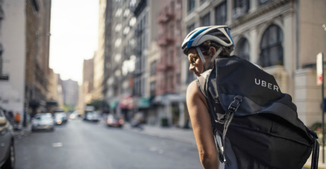 A cyclist wearing an Uber backpack